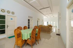 - une salle à manger avec une table et des chaises dans l'établissement RedDoorz Syariah near Simpang Sekip Palembang, à Palembang