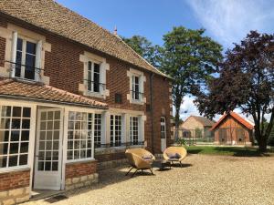 two chairs sitting outside of a brick house at L'evidence in Bragny-sur-Saône