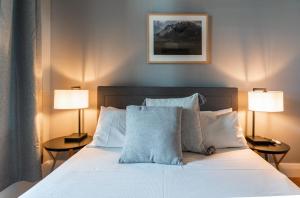 a bedroom with a white bed with two lamps at The Tasmanian Inn in Hobart