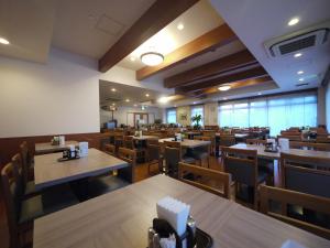 an empty restaurant with wooden tables and chairs at Hotel Route-Inn Nago in Nago
