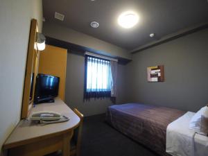 Lova arba lovos apgyvendinimo įstaigoje Hotel Route-Inn Nago