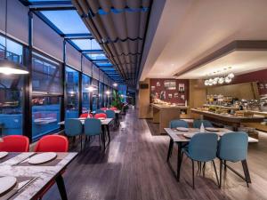 a restaurant with tables and chairs and a bar at Mercure Suzhou Downtown in Suzhou