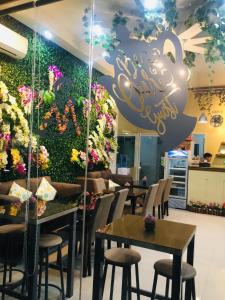 restauracja ze stołami i krzesłami oraz ścianą pełną kwiatów w obiekcie Mt Moriah Inn and Resto w Ozamis