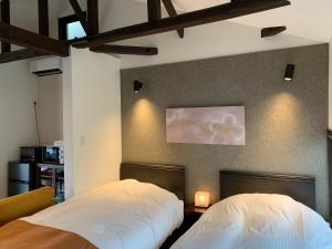 a bedroom with two beds and a painting on the wall at Kanazawa Bettei Yuan in Kanazawa