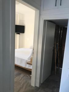 a door to a bedroom with a bed and a television at AVRA 1 in Kriopigi