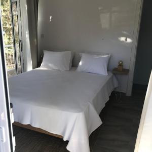 a white bed with white sheets and pillows at AVRA 1 in Kriopigi