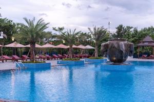 a pool at a resort with a large vase in the middle at Pacific Hotel & Spa in Siem Reap