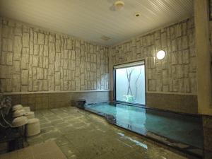 a swimming pool in a room with a window at Hotel Route-Inn Kakegawa Inter in Kakegawa