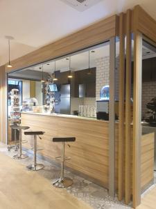 a restaurant with two stools in front of a counter at Panam Hotel PARIS GAMBETTA- Place Gambetta-Mairie du 20 emme in Paris