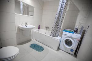 a bathroom with a washing machine and a sink at Fresh Green Kabaty apartment 4 in Warsaw +25 photos