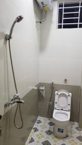 ein Bad mit einer Dusche und einem WC in einer Kabine in der Unterkunft Latte Motel in Dong Hoi