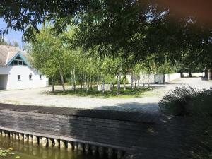 Blick auf einen Garten mit Bäumen und ein Gebäude in der Unterkunft Bootshaus am See in Neusiedl am See