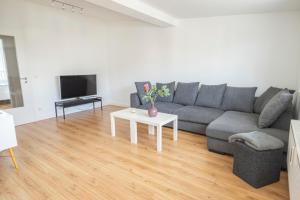 uma sala de estar com um sofá cinzento e uma mesa em Dehnhaide Apartments em Hamburgo