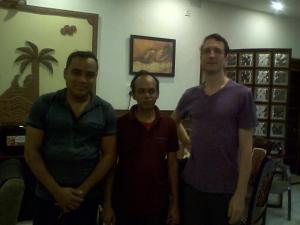 Drei Männer stehen nebeneinander in einem Raum in der Unterkunft Om Sai Villa Guesthouse in Kalkutta