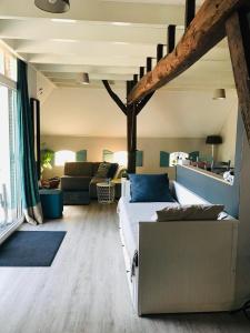 een woonkamer met een bed en een bank bij Het Achterhuis - Buitenplaats Ruitenveen, privé! in Nieuwleusen