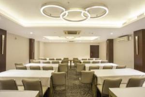 a room with rows of tables and chairs and a chandelier at Connaught Royale Delhi in New Delhi