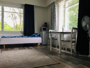 a bedroom with a bed and a table and window at Villa Saimaan Sydän in Puumala