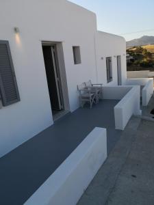 a white building with a balcony with a table at Ftelia Breeze in Klouvas