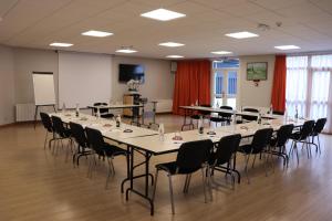 una sala de conferencias con una mesa larga y sillas en Hotel Normandy, en Vernon