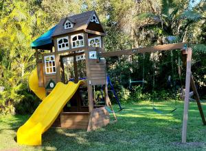 a playground with a house and a slide at Beerwah Motor Lodge in Beerwah