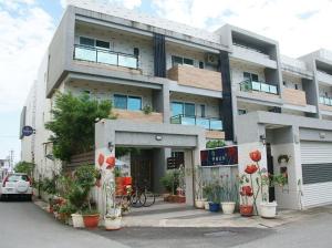 a large white building with plants in front of it at Walk in the Wind Homestay in Taitung City