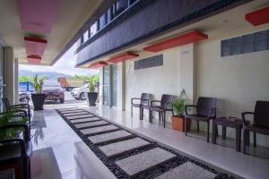 een veranda met stoelen, een tafel en een auto bij RedDoorz near Taman Kota Ternate in Ternate