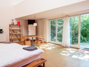 a bedroom with a bed and a table and windows at Darmstadt Loft in Darmstadt
