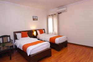 een hotelkamer met 2 bedden en een raam bij Hotel Mums Home in Kathmandu