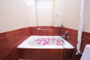 a bathroom with a tub filled with pink flowers at Hotel Mums Home in Kathmandu