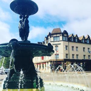 a fountain in a square with a building in the background at Hotel Normandy in Vernon