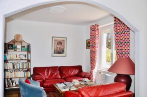 a living room with a red couch and a table at Les hauts de Kersudal in Audierne