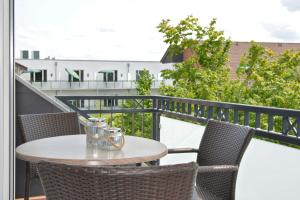 einen Tisch und Stühle auf einem Balkon mit Aussicht in der Unterkunft Kurhotel Drei Birken in Bad Rothenfelde