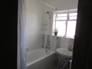 een badkamer met een bad en een wastafel bij Libem Lodge 11 in Edenvale