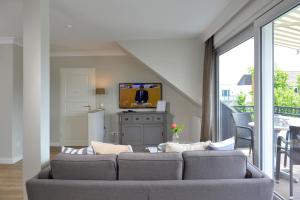 a living room with a couch and a tv at Kurhotel Drei Birken in Bad Rothenfelde