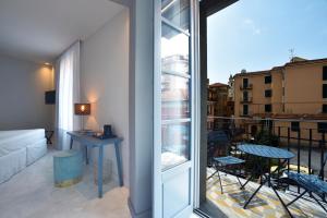 um quarto com uma varanda com uma mesa e uma vista em Boutique Hotel de la Ville em Laigueglia