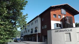 un edificio con un letrero al lado de una calle en Côté Hôtel, en Légny