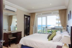 a bedroom with a bed and a desk and a window at Ballito Manor Beach 405 - FAMILY ONLY - With Generator in Ballito