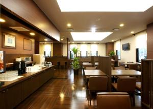 a restaurant with wooden floors and tables and chairs at Hotel Route-Inn Handakamezaki in Handa