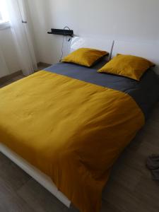 1 cama amarilla grande con 2 almohadas amarillas. en Loc126 en Montreuil-Bellay