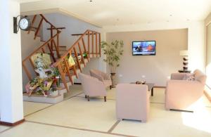 a living room with a couch and chairs and a clock at Santa Ines Bella Vista Hotel in Bella Vista