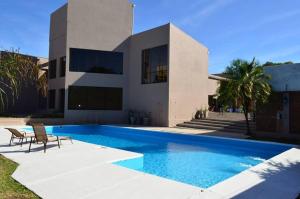 a house with a swimming pool in front of a house at Santa Ines Bella Vista Hotel in Bella Vista