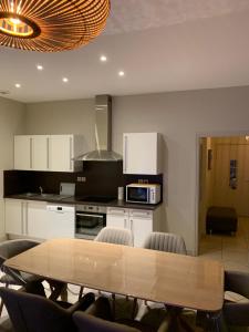 a kitchen with a wooden table and chairs in it at Appartement de 95 m2 bien situé in Boulogne-sur-Mer