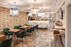 a restaurant with wooden tables and green chairs at Wellion Sukharevskiy in Moscow