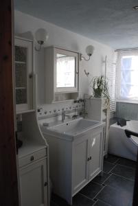a white bathroom with a sink and a tub and a bath tub at Ferienwohnung Christina in Vaihingen an der Enz