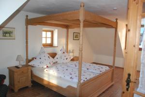 a bedroom with a wooden canopy bed with pillows at Ferienwohnung Christina in Vaihingen an der Enz