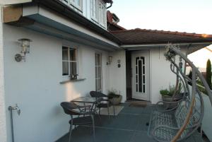 un patio avec des chaises et une table devant une maison dans l'établissement Ferienwohnung Christina, à Vaihingen-sur-l'Enz