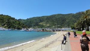 a group of people walking along a beach at Astonishing Views Superb Waterfront Apartment in Picton