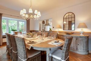 uma sala de jantar com uma mesa e cadeiras e um lustre em La Villa des Sources à 500 mètres du circuit em Francorchamps
