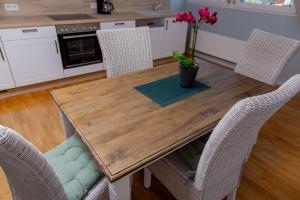 une table en bois avec des chaises et un vase avec des fleurs. dans l'établissement Weingut Gerd Müllers, à Kröv