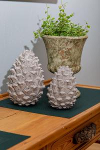 dos jarrones plateados de piña sobre una mesa con una planta en Weingut Gerd Müllers, en Kröv